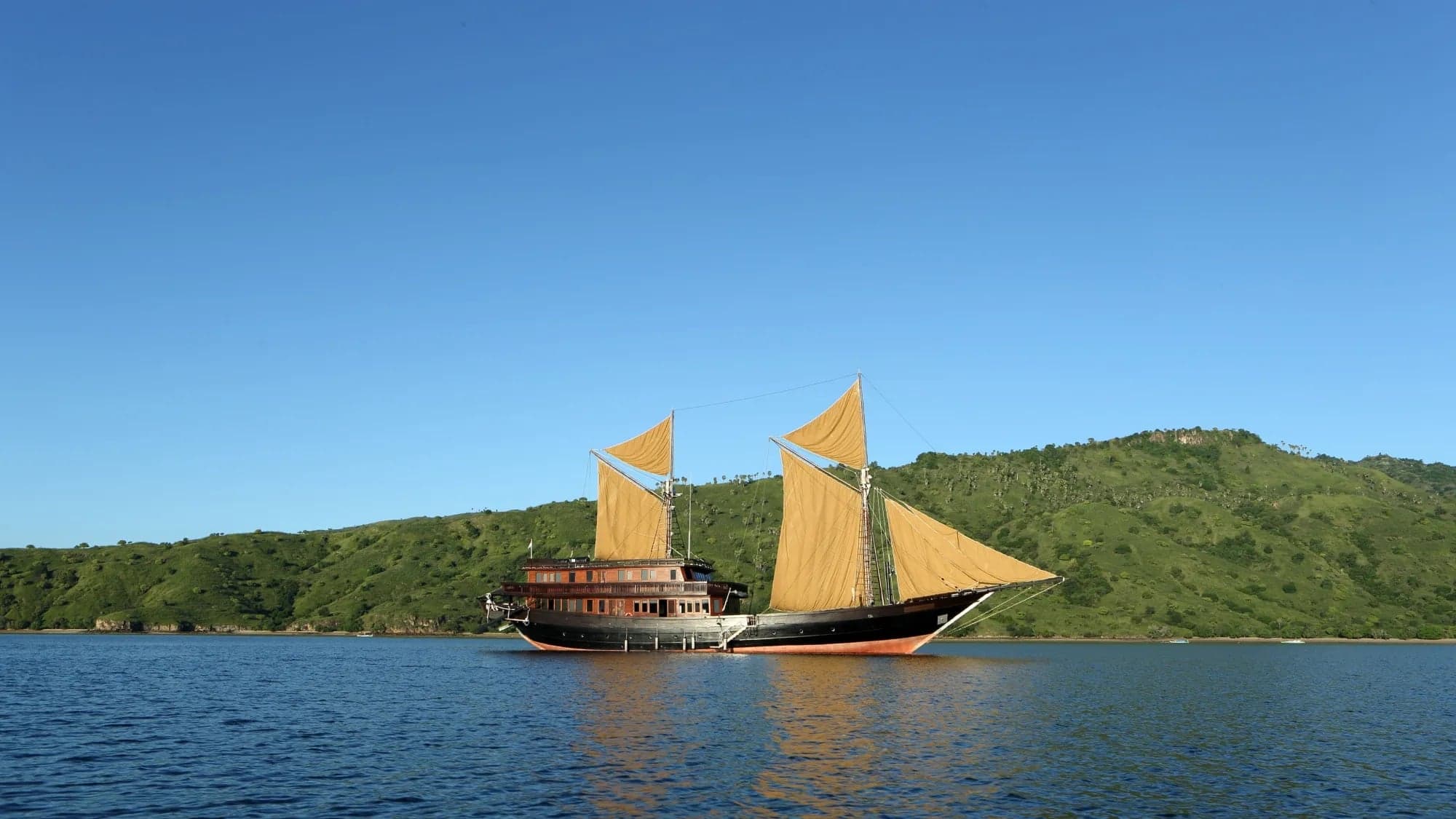 Sail Indonesia with Alila Purnama liveaboard, diving Raja Ampat and Komodo. Encounter manta rays, reef sharks, and macro life while enjoying luxury on a traditionally crafted vessel