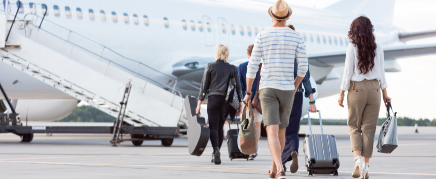Passengers boarding a plane at a tropical airport, highlighting the air travel component of a Galápagos or Cocos Island diving expedition.