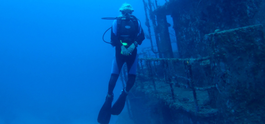 Female Diver floating vertically alongside the Halliburton shipwreck, Honduras 