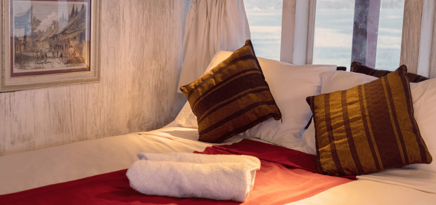 cabin Seven Seas Liveaboard Indonesia Warm wood-crafted stateroom on Seven Seas liveaboard with en-suite bathroom and large ocean window.