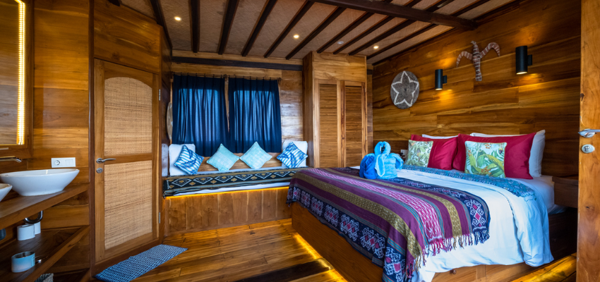 cabin Tiger Blue Liveaboard Indonesia Family-friendly premium cabin layout inside Tiger Blue with warm wood accents and spacious bunk styling.