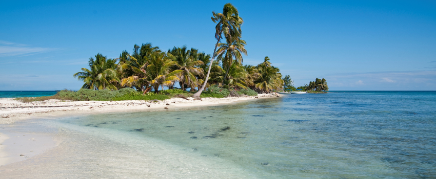 White sand and turquoise water at Laughing Bird Caye, Belize, near Caribbean reefs and atolls for December diving.